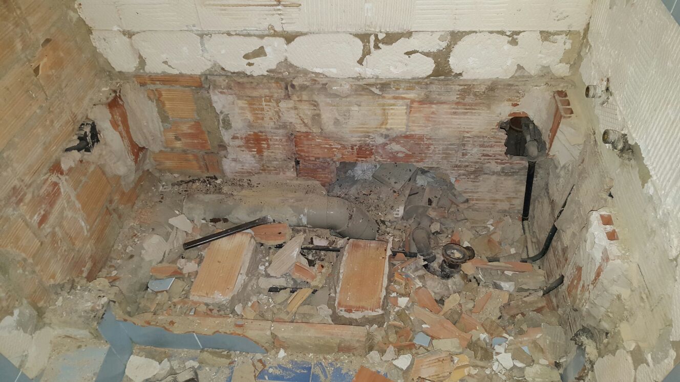 Tuberías escondidas en una bañera demolida para cambio a plato de ducha
